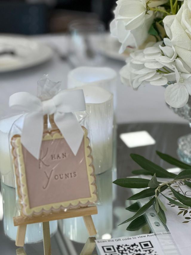 Candlelit place card with ribbon and olive leaves at the Pop Up for Palestine charity dinner